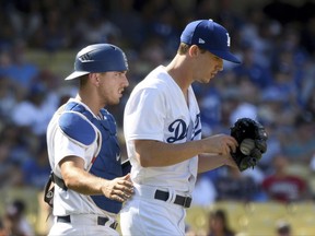 Los Angeles Dodgers catcher Austin Barnes goes to the mound with pitcher Walker Buehler during a jam in the eighth inning of a baseball game against the Colorado Rockies, Sunday, Sept. 10, 2017, in Los Angeles. (AP Photo/Michael Owen Baker)