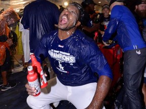 Los Angeles Dodgers' Yasiel Puig has sparkling wine poured onto him in the locker room after the Dodgers won the NL West title with a 4-2 defeat of the San Francisco Giants in a baseball game, Friday, Sept. 22, 2017, in Los Angeles. (AP Photo/Mark J. Terrill)