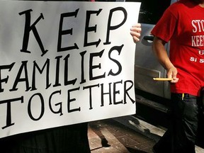 A demonstrator carries a sign during a march outside federal court in New Orleans, Friday, Sept. 22, 2017. With immigrants and their advocates chanting and beating drums outside, a federal appeals court heard arguments Friday on whether it should allow a Texas law aimed at combatting "sanctuary cities" to immediately take effect. (AP Photo/Stacey Plaisance Jenkins)