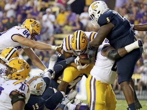 LSU running back Derrius Guice, center, scores a touchdown during the first half of an NCAA college football game against Chattanooga in Baton Rouge, La., Saturday, Sept. 9, 2017. (AP Photo/Rusty Costanza)