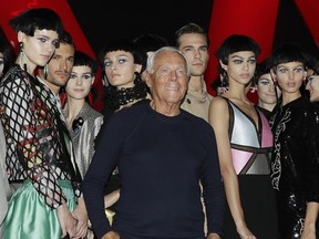 Designer Giorgio Armani, centre, poses with models at the end of his womens Fall/Winter 2018/19 fashion collection, presented in Milan, Italy, Friday, Sept. 22, 2017. (AP Photo/Antonio Calanni)