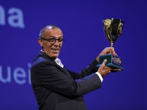 Kamel El Basha holds aloft the Volpi Cup for best actor for his role in 'The Insult' during the award ceremony at the 74th Venice Film Festival at the Venice Lido, Italy, Saturday, Sept. 9, 2017. (AP Photo/Domenico Stinellis)