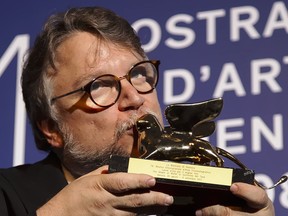 Guillermo del Toro kisses the Golden Lion for best film for 'The Shape Of Water' during the awards photo call at the 74th Venice Film Festival at the Venice Lido, Italy, Saturday, Sept. 9, 2017. (AP Photo/Domenico Stinellis)