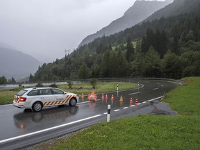 A car stands in front of a closed road between Casaccia and Vicosoprano, Friday, Sept. 1, 2017 after a new mudslide preceded by thunderstorms swept through villages in southeastern Switzerland, along the same path where a powerful, rocky mudslide left eight people missing and feared dead last week. (Giancarlo Cattaneo/Keystone via AP)