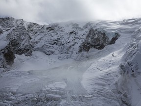 The glacial ice avalanche of the Trift Glacier above the village is pictured this morning in Saas-Grund, Valais, Switzerland, Sunday, Sept. 10, 2017. Part of the glacier has broken off and tumbled onto a glacier below after some 220 people in a small nearby town were evacuated as a precaution. (Dominic Steinmann/Keystone via AP)