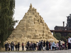 Visitors surround a sandcastle at the Landschaftspark in Duisburg, Germany, Friday, Sept. 1, 2017.