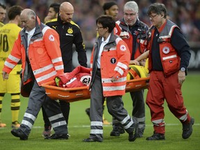German Red Cross workers carry injured Dortmund player Marcel Schmelzer on a stretcher from the field during the German Bundesliga soccer match between SC Freiburg and Borussia Dortmund in the Schwarzwald stadium in Freiburg, Germany, Saturday, Sept. 9, 2017. (Patrick Seeger/dpa via AP)