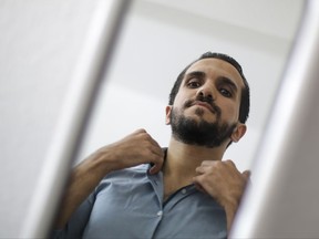 In this photo taken Thursday, Sept. 7, 2017, Syrian refugee Nawras Ali poses for a photo at his apartment after an interview with the Associated Press in Berlin, Germany. Two years after her controversial decision to open Germany's doors to hundreds of thousands of migrants, German Chancellor Angela Merkel is on track to winning her 4th term in national elections this month. Ali the 25-year-old translator from Damascus arrived in Germany two years ago and after getting asylum, studying German and moving to Berlin, the young Syrian has found a job as a language editor at a documentary film company. (AP Photo/Markus Schreiber)