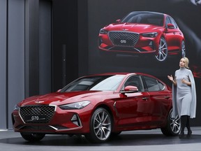 Bozhena Lalova, a head of Genesis Color and Trim of Hyundai Motor Co., speaks to the media next to a new sedan Genesis G70 during its unveiling ceremony in Hwaseong, South Korea, Friday, Sept. 15, 2017. Hyundai Motor will launch its first midsize sports sedan under the Genesis brand in South Korea next week and in the U.S. early next year, the latest attempt by the emerging Korean luxury brand to challenge BMW's 3 series and other European premium cars. (AP Photo/Lee Jin-man)