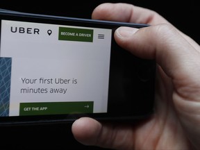 The Uber website is displayed on a phone in London, Friday, Sept. 22, 2017. London's transport authority said Friday it won't renew Uber's license to operate in the British capital, arguing that it demonstrates a lack of corporate responsibility with implications in public safety and security. (AP Photo/Kirsty Wigglesworth)