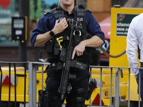 An armed police officer stands nearby after an incident on a tube train at Parsons Green subway station in London, Friday, Sept. 15, 2017