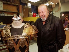 FILE- In this Sept. 6, 2000 file photo, Sir Peter Hall, director of the epic play "Tantalus," poses with one of the suits of armor being prepared for use in the 10 1/2-hour play at the Denver, Colo., Center for the Performing Arts . Peter Hall, founder of the Royal Shakespeare Company and ex-director of Britain's National Theatre, has died, Tuesday, Sept. 12, 2017. He was 86. (AP Photo/David Zalubowski, File)
