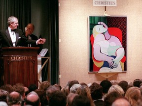 FILE - In this Nov. 10, 1997 file photo, Picasso's "The Dream" is auctioned by auctioneer Christopher Burge at Christie's auction house in New York. An exhibition in Paris and London will reunite three Picasso nudes painted days apart but not displayed together for almost a century, the Tate Modern gallery said Thursday, Sept. 21, 2017.  (AP Photo/Emile Wamsteker, file)