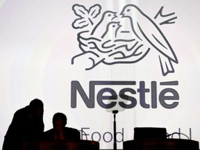 FILE - In this April 7, 2016 file photo Nestle's directors speak in front of the Nestle's logo during the general meeting of Nestle Group, in Lausanne, Switzerland. The world's biggest food and drinks company, Nestle, says it is buying husband-and-wife startup Sweet Earth, which sells frozen burritos stuffed with quinoa, beans and other vegetarian ingredients. The Swiss company, whose frozen food brands include Lean Cuisine and Stouffer's, said Thursday, Sept. 7, 2017 that the deal will boost its presence in the fast-growing market for plant-based foods.(Laurent Gillieron/Keystone via AP, file)