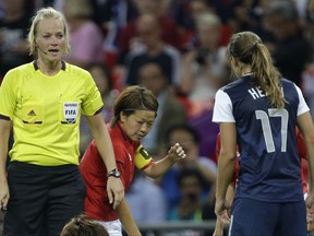 FILE- In this Thursday, Aug. 9, 2012 file photo, referee Bibiana Steinhaus from Germany, left, speaks to a Japanese player during the women's soccer gold medal match of the at the 2012 Summer Olympics in London. Steinhaus will make history in Germany on Sunday, Sept. 10, 2017, when she becomes the first woman to referee a Bundesliga game. (AP Photo/Julie Jacobson, File)