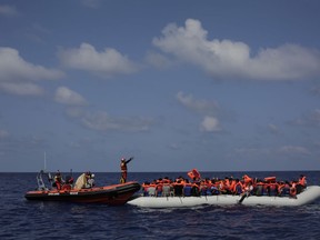 Migrants wait to be rescued from a rubber dinghy by members of the Spanish NGO ProActiva Open Arms during an operation  on the Mediterranean Sea, Wednesday, Sept. 6, 2017. ProActiva Open Arms rescued more than 200 migrants Wednesday morning from foundering rubber dinghies about 25 miles north of the Libyan coastal town of al-Khums. (AP Photo/Bram Janssen)