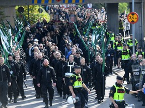 Members of the Nordic Resistance Movement march in central Goteborg, Sweden, Saturday Sept. 30, 2017. The authorities say the Nordic Resistance Movement expects some 1,000 people to march Saturday while as many as 10,000 people could counter-demonstrate. (Fredrik Sandberg/TT via AP)