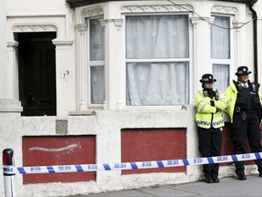 Police stand outside a property in Thornton Heath, south London, after a teenager was arrested by detectives investigating the bomb that partially exploded on a London subway last week, on Thursday, Sept. 21, 2017.  The bomb injured 30 people when it detonated inside a crowded subway car on Friday, Sept. 15. (Jonathan Brady/PA via AP)