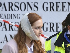 An injured woman is assisted by a police officer close to Parsons Green station in west London after an explosion on a packed London Underground train, Friday, Sept. 15, 2017. London's Metropolitan Police says a fire on the London subway has been declared a "terrorist incident." (Stefan Rousseau/PA via AP)