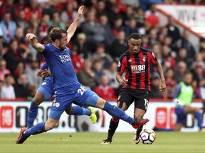 Leicester City's Christian Fuchs, left, and AFC Bournemouth's Junior Stanislas battle for the ball during their English Premier League soccer match at the Vitality Stadium, Bournemouth, England, Saturday Sept. 30, 2017. (Simon Cooper/PA via AP)