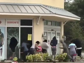 People loot a Fort Lauderdale store as Hurricane Irma approaches the city.