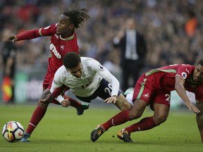 Tottenham's Dele Alli, centre, is fouled by Swansea's Renato Sanches, left, and Swansea's Kyle Naughton during the English Premier League soccer match between Tottenham Hotspur and Swansea City at Wembley stadium in London, Saturday Sept. 16, 2017. (AP Photo/Tim Ireland)