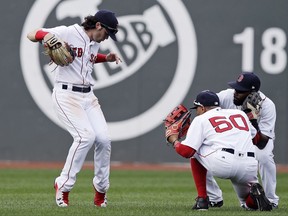 Boston Red Sox left fielder Andrew Benintendi, left, celebrates with teammates after defeating the Oakland Athletics 6-2 in a baseball game at Fenway Park in Boston, Thursday, Sept. 14, 2017. Benintendi had three RBI's in the game. (AP Photo/Charles Krupa)