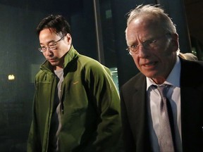 FILE - In this Friday, Dec. 19, 2014, file photo the former supervisory pharmacist for the New England Compounding Center, Glenn Chin, left, leaves the federal courthouse in Boston with his attorney Stephen Weymouth after a hearing to announce conditions of his bail and release. Chin who was the supervisory pharmacist at the now-closed New England Compounding Center in Framingham is heading to trial with opening arguments in the case are expected on Tuesday, Sept. 19, 2017. He faces up to life in prison if convicted of all counts of second-degree murder under federal racketeering law. (AP Photo/Elise Amendola, File)