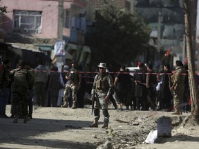 Security forces inspect the site of a suicide attack outside a Shiite mosque in Kabul, Afghanistan, Friday, Sept. 29, 2017. A suicide bomber blew himself up outside a Shiite mosque in the Afghan capital Kabul on Friday, killing four people and wounding 20 others, authorities said. (AP Photo/Massoud Hossaini)