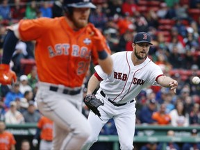 Boston Red Sox's Drew Pomeranz, right, tosses to first base on the single by Houston Astros' Derek Fisher (21) during the third inning of a baseball game in Boston, Saturday, Sept. 30, 2017. (AP Photo/Michael Dwyer)