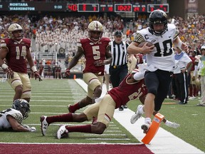 Wake Forest quarterback John Wolford (10) rushes for a touchdown past the tackle attempt from Boston College defensive back Lukas Denis (21) during the first half of an NCAA college football game, Saturday, Sept. 9, 2017, in Boston. (AP Photo/Mary Schwalm)