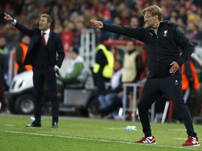 Liverpool coach Juergen Klopp, foreground, gestures besides Spartak coach Massimo Carrera during the Champions League soccer match between Spartak Moscow and Liverpool in Moscow, Russia, Tuesday, Sept. 26, 2017. (AP Photo/Alexander Zemlianichenko)