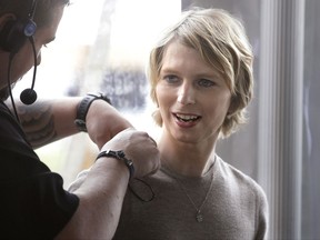 Chelsea Manning, right, is assisted with a microphone, Sunday, Sept. 17, 2017, before a scheduled appearance at a forum, in Nantucket, Mass. The planned forum is part of The Nantucket Project's annual gathering on the island of Nantucket founded to bring together creative thinkers. Manning is a former U.S. Army intelligence analyst who spent seven years in prison for sharing classified documents. (AP Photo/Steven Senne)