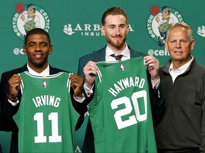 Boston Celtics' Kyrie Irving, left, and Gordon Hayward hold up their new jerseys with General Manager Danny Ainge, right, during a news conference in Boston, Friday, Sept. 1, 2017. (AP Photo/Winslow Townson)