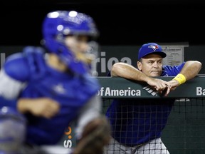 Toronto Blue Jays manager John Gibbons leans against the dugout rail beyond Blue Jays catcher Raffy Lopez during the third inning of a baseball game against the Baltimore Orioles in Baltimore, Friday, Sept. 1, 2017. Baltimore won 1-0 in 13 innings. (AP Photo/Patrick Semansky)