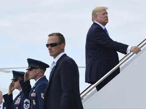 President Donald Trump up the steps of Air Force One at Andrews Air Force Base in Md., Tuesday, Sept. 26, 2017, where he is heading to New York. Trump will meet with major GOP donors for a private dinner in New York as part of a fundraising effort for the Republican National Committee. (AP Photo/Susan Walsh)