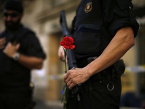 A regional police officer holds a carnation in Barcelona, Spain, Sunday, Sept. 24, 2017. Thousands of Catalan separatists are rallying in public squares in Barcelona and other towns in support of a disputed referendum on independence of the northeastern region from Spain. Many are carrying pro-independence flags and signs calling for the Oct. 1 vote that the Spanish government calls illegal and has pledged to stop. (AP Photo/Manu Fernandez)