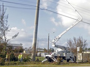 FILE - In this  Sept. 14, 2017, file photo, a crew checks power cables as utility crews work to reestablish power in the aftermath of Hurricane Irma in Key West, Fla. Eight days after Hurricane Irma ripped through Florida, hundreds of thousands of customers in the state remain without power, adding to the misery that came with the savage and deadly storm. (AP Photo/Alan Diaz, File)