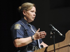 FILE- In an Oct. 1, 2015 file photo, Michigan State Police Director Col. Kriste Kibbey Etue leads a focus group discussion at Benton Harbor High School, in Benton Harbor, Mich. The 23-member Michigan Legislative Black Caucus is calling for the resignation of Etue for sharing a post on her Facebook page that called NFL players protesting during the national anthem "degenerates." The group of lawmakers said Wednesday, Sept. 27, 2017, if Etue doesn't resign, then Gov. Rick Snyder should fire her.  (Don Campbell/The Herald-Palladium via AP, File)