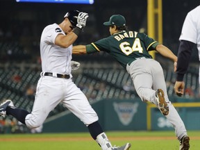 Oakland Athletics relief pitcher Michael Brady (64) reaches for a throw from second base as Detroit Tigers catcher James McCann (34) crosses first base on a fielders choice in the sixth inning of a baseball game in Detroit, Tuesday, Sept. 19, 2017. (AP Photo/Paul Sancya)
