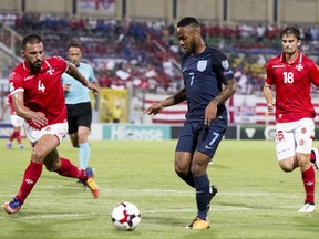 England's Raheem Sterling, center, is challenged by Malta's Steve Borg, left, during the World Cup group F qualifying soccer match between Malta and England, at the Ta Qali stadium, in Valletta, Malta, Friday Sept.1, 2017. (AP Photo/Rene Rossignaud)