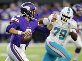 Minnesota Vikings quarterback Taylor Heinicke (6) runs from Miami Dolphins defensive end Terrence Fede, right, during the first half of an NFL preseason football game, Thursday, Aug. 31, 2017, in Minneapolis. (AP Photo/Jim Mone)
