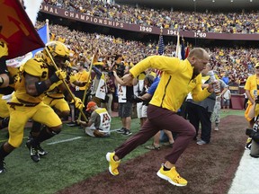 Minnesota head coach P.J. Fleck lead his team onto the field before the start of an NCAA college football game against Middle Tennessee on Saturday, Sept. 16, 2017, in Minneapolis. (AP Photo/John Autey)
