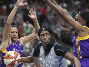 FILE - In this July 6, 2017, file photo, Minnesota Lynx center Sylvia Fowles drives between Los Angeles Sparks players, including Candace Parker, left, during the second half of a WNBA basketball game, in St. Paul, Minn. Fowles had a stellar year to lead Minnesota to the top seed in the WNBA playoffs. Her efforts earned her Associated Press WNBA Player of the Year honors on Tuesday, Sept. 5, 2017. (Elizabeth Flores/Star Tribune via AP, File)