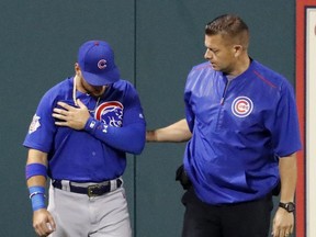 Chicago Cubs center fielder Albert Almora Jr. holds his shoulder as he is helped off the field by Cubs trainer PJ Mainville after slamming into the outfield wall chasing an RBI double by St. Louis Cardinals' Paul DeJong during the fifth inning of a baseball game Tuesday, Sept. 26, 2017, in St. Louis. (AP Photo/Jeff Roberson)