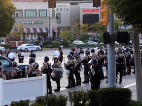 Police dressed in riot gear stage in the front of the  Saint Louis Galleria mall to clear protesters from the streets on Wednesday, Sept. 20, 2017, in St. Louis. St. Louis County police say they broke up a demonstration near the upscale mall because protesters weren't listening to instructions and tried to evade two lines of officers blocking the on-ramp to a highway. The protesters broke into groups, with some milling around near the highway entrance, some in the mall parking lot and others on a nearby street. (Laurie Skrivan/St. Louis Post-Dispatch via AP)