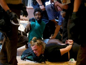 Protesters are bound after being arrested at the St. Louis Galleria mall in Richmond Heights, after several hundred people demonstrated in protest over the recent acquittal of a white former officer in the killing of a black suspect, in St. Louis, Saturday, Sept. 23, 2017. Several people were arrested at the upscale Galleria mall where demonstrators marched and chanted among shoppers. The St. Louis Post-Dispatch reported officers briefly cleared the mall after some members of the group became unruly.  (Christian Goode /St. Louis Post-Dispatch via AP)