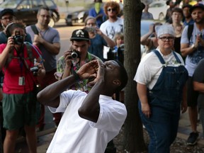 State Rep. Bruce Franks chants in front of the Buzz Westfall Justice Center as more than a hundred people wait for the release of almost two dozen people arrested earlier in the day at the Saint Louis Galleria mall, Saturday, Sept. 23, 2017, in Clayton, Mo. Demonstrations have been ongoing after a judge's ruling on Sept. 15 that found white former police officer Jason Stockley not guilty of first-degree murder in the 2011 shooting death of a 24-year-old black drug suspect Anthony Lamar Smith. (Robert Cohen/St. Louis Post-Dispatch via AP)