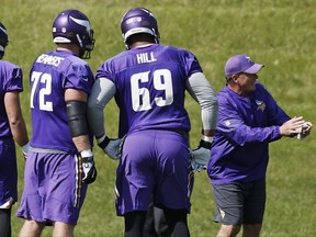 Clancy Barone, Minnesota Vikings tight end coach, gives instructions as offensive linemen Mike Remmers, left, and Rashod Hill listen in during the NFL football team's practice Tuesday, Sept. 5, 2017, in Eden Prairie, Minn. The Minnesota Vikings are going to start the season with a completely remade offensive line. New faces Riley Reiff, Mike Remmers and Pat Elflein will be counted on to improve a unit that was one of the league's worst last season. (AP Photo/Jim Mone)