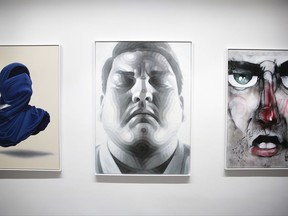 The paintings, from left: 'Shirt Mask x Paper Plane' by Numo Viegas, 'The Fighter' by El Mac and 'Street Face' by Lister displayed inside the exhibition of the new Urban Nation Museum for Urban Contemporary Art in Berlin, Germany, Monday, Sept. 18, 2017. The opening exhibition, which will last for around nine months, aims to introduce visitors to the culture of urban art. Director Yasha Young worked with eight curators from various countries to produce a show that explores strands including portraits, pop art and activism. (AP Photo/Markus Schreiber)